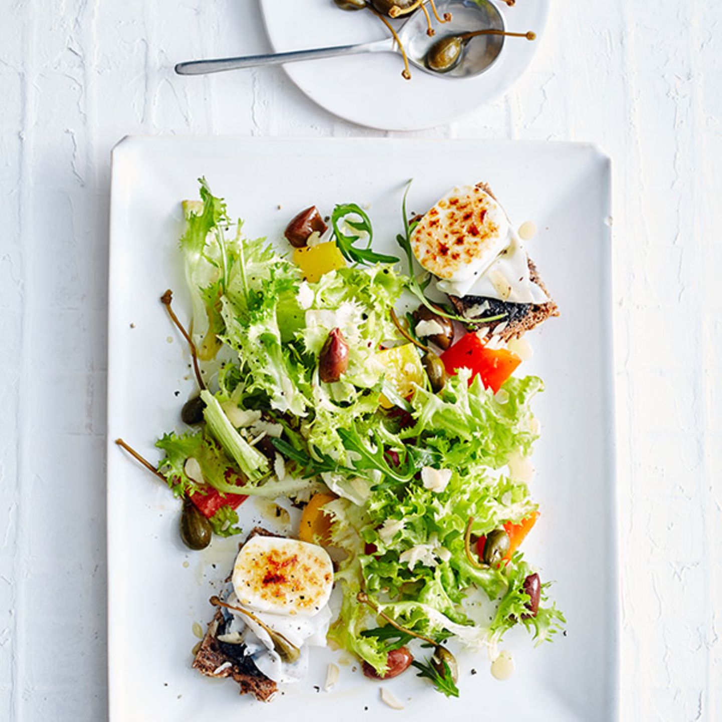 Salat mit Ziegenkäse-Crostini, Kapernäpfeln und Oliven