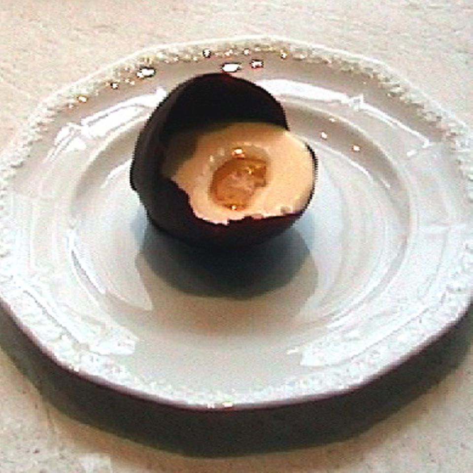 Weiße Schokoladenmousse in der Schokoladeneierschale mit Mangopüree