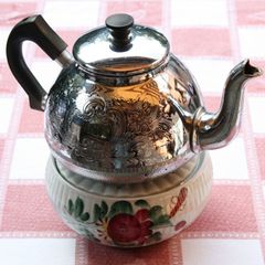 Anschließend zieht der Teeaufguss circa 5 Minuten auf dem Ofen oder einem Stöfchen. Dann wird Wasser aufgegossen. Zum Servieren kann man jede einzelne Tasse sieben, den Tee durch ein Sieb in eine (vorgewärmte) Servierkanne umgiessen oder einen Siebeinsatz für die Kanne benutzen. Viele Ostfriesen trinken ihren Tee aber auch mit den Teeblättern.