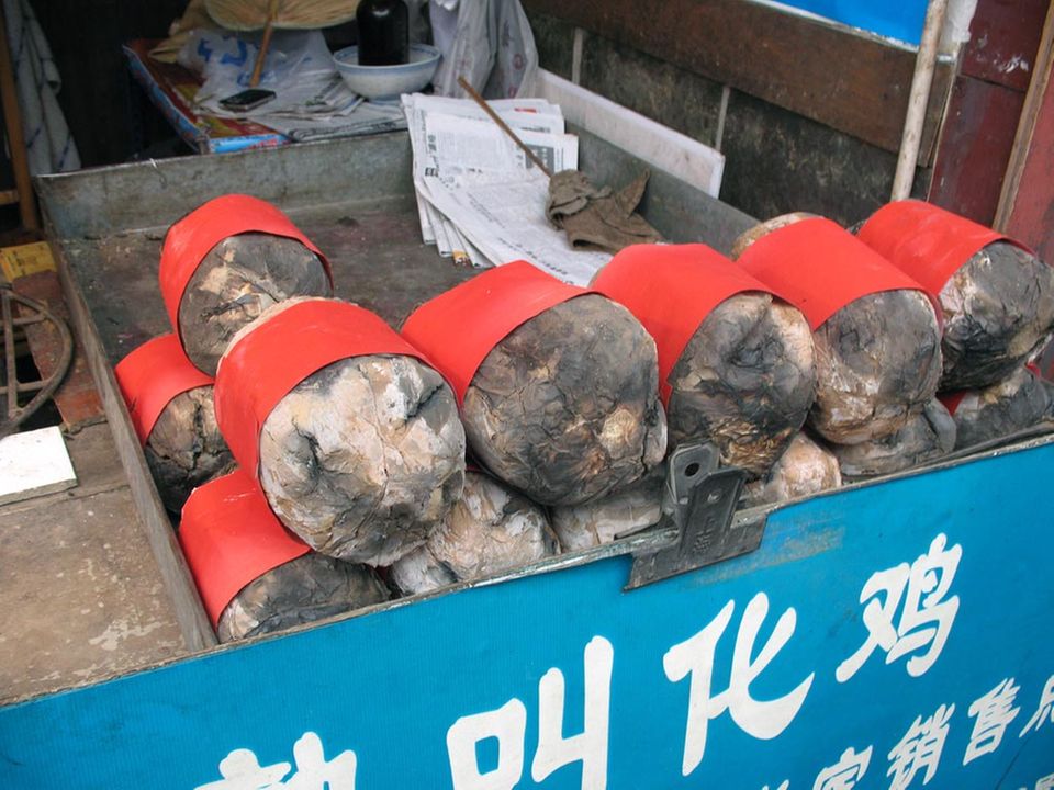 In einen roten Papierstreifen gewickelt wird das Bettlerhuhn heute in den Straßen verkauft In einen roten Papierstreifen gewickelt wird das Bettlerhuhn heute in den Straßen verkauft