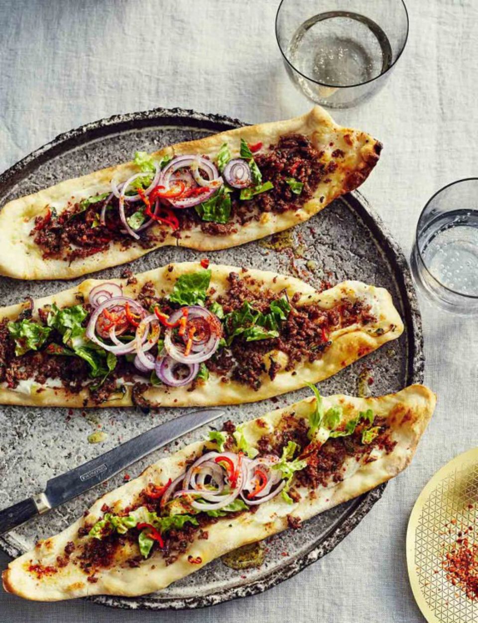 Pide gefüllt mit Lammhack, Chili, Salat und roten Zwiebeln Pide gefüllt mit Lammhack, Chili, Salat und roten Zwiebeln