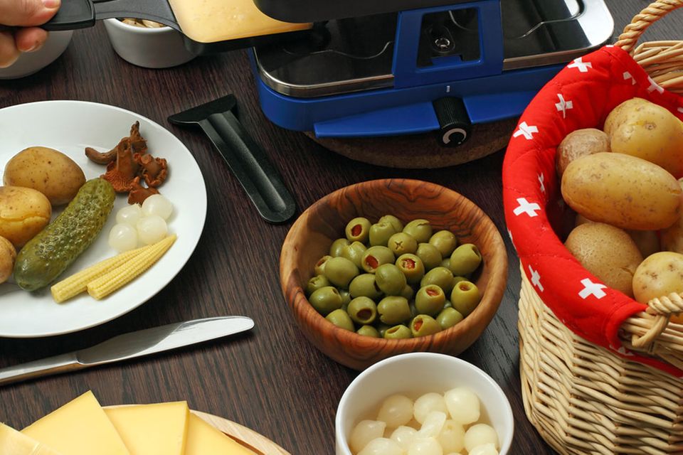 Alle Leckereien auf dem Tisch: Käse, Speck, Kartoffeln, Cornichons, Perlzwiebeln, Pilze und Paprika