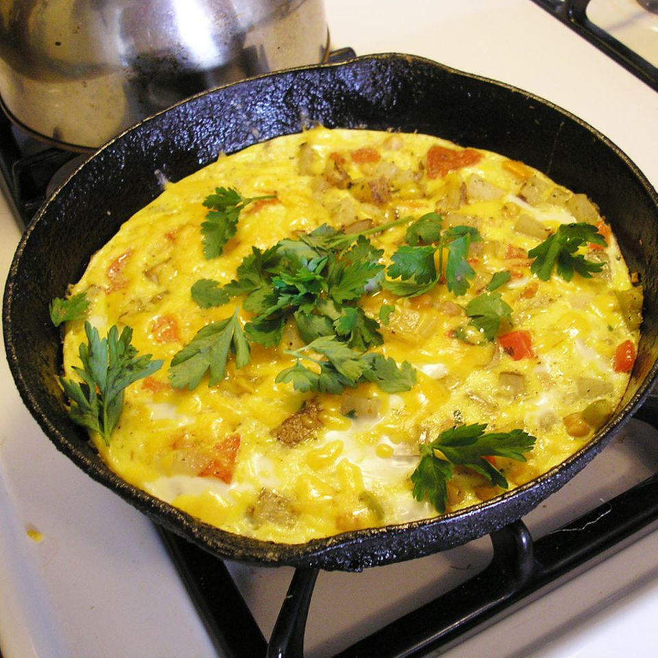 Lassen Sie die Frittata langsam in einer Pfanne stocken Lassen Sie die Frittata langsam in einer Pfanne stocken