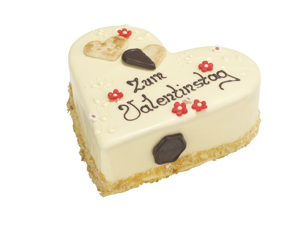 Die Valentinstagstorte hat einen Guss aus weißer Schokolade Die Valentinstagstorte hat einen Guss aus weißer Schokolade