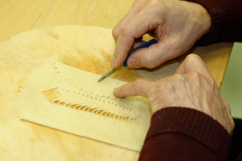 In sorgfältiger Handarbeit werden die Muster in das Laufabrauð geschnitzt In sorgfältiger Handarbeit werden die Muster in das Laufabrauð geschnitzt
