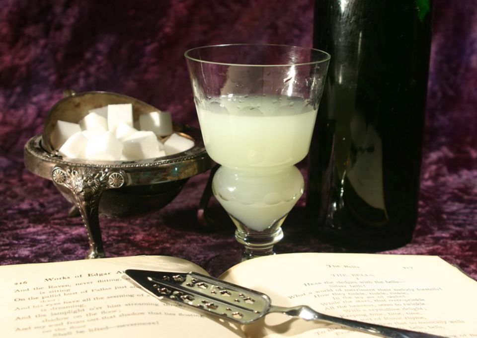 In das Glas wird bis zur Einbuchtung Absinth eingefüllt. Durch Zugabe von Wasser entsteht die Eintrübung. In das Glas wird bis zur Einbuchtung Absinth eingefüllt. Durch Zugabe von Wasser entsteht die Eintrübung.