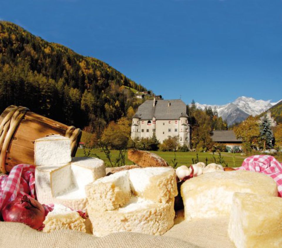 Käse vor einem der Wahrzeichen von Sand in Taufers: Ansitz „Neumelans“ Käse vor einem der Wahrzeichen von Sand in Taufers: Ansitz „Neumelans“