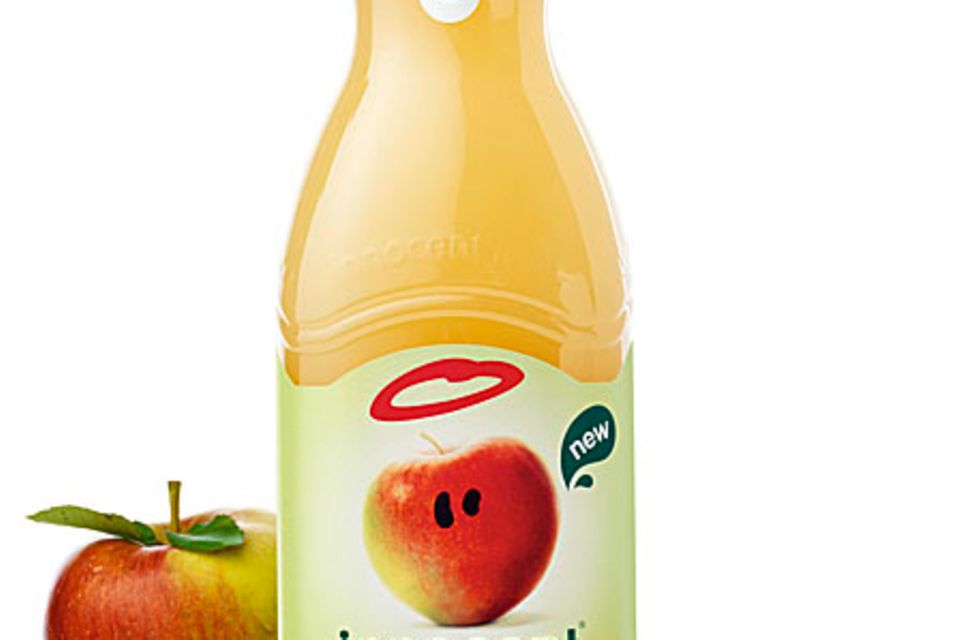 Acht ganze Äpfel stecken in einer Flasche innocent apple juice