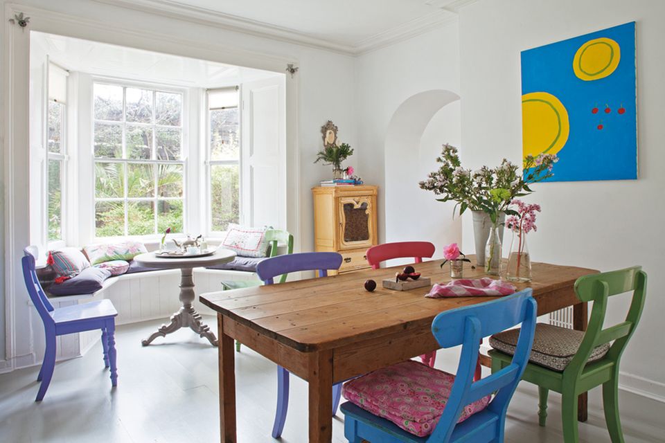 Das helle Esszimmer in der Regency-Villa in einem Vorort von Dublin - mit Kieferntisch und bunt lackierten Küchenstühlen Das helle Esszimmer in der Regency-Villa in einem Vorort von Dublin - mit Kieferntisch und bunt lackierten Küchenstühlen