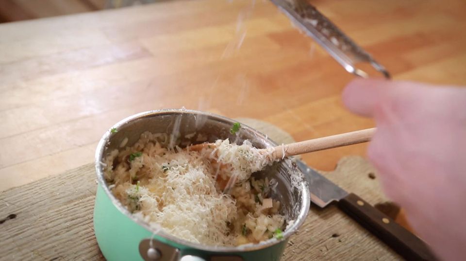 Fabio Haebel rührt Parmesan in das Risotto. Fabio Haebel rührt Parmesan in das Risotto.