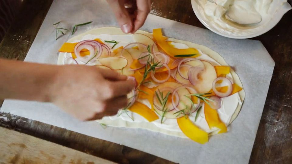 Anne Lucas belegt den Flammkuchen-Teig mit frischen Zutaten. Anne Lucas belegt den Flammkuchen-Teig mit frischen Zutaten.