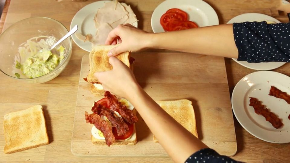 Anna Walz breitet klassische Ney York Club Sandwiches zu. Anna Walz breitet klassische Ney York Club Sandwiches zu.