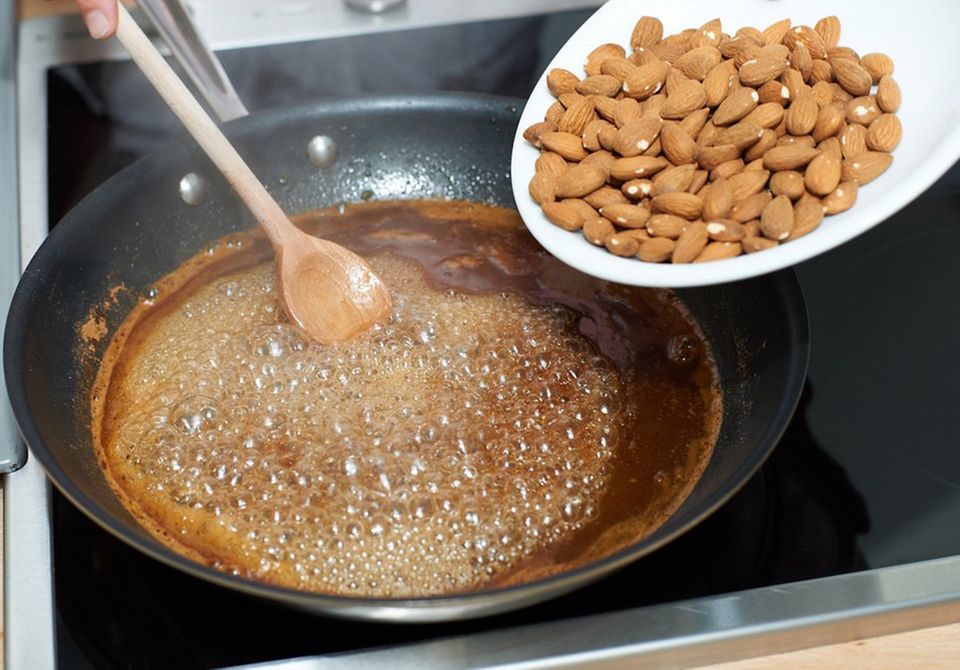 Mandeln zu Zucker-Wasser in Pfanne geben Mandeln zu Zucker-Wasser in Pfanne geben