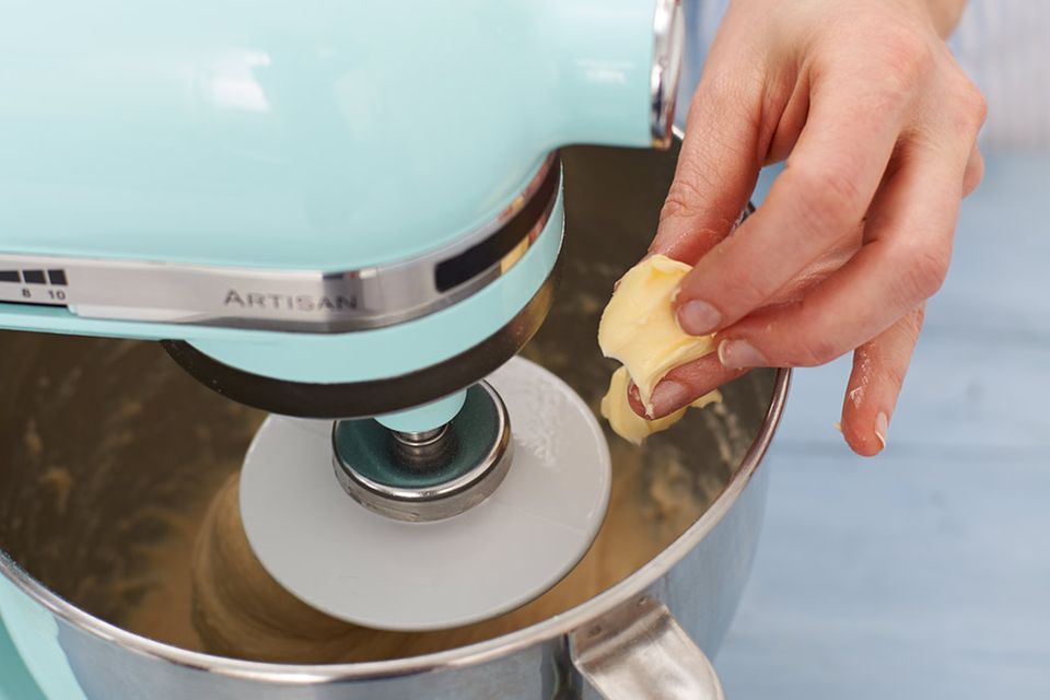 Für den Teig Butter in Stückchen in die laufende Küchenmschine geben