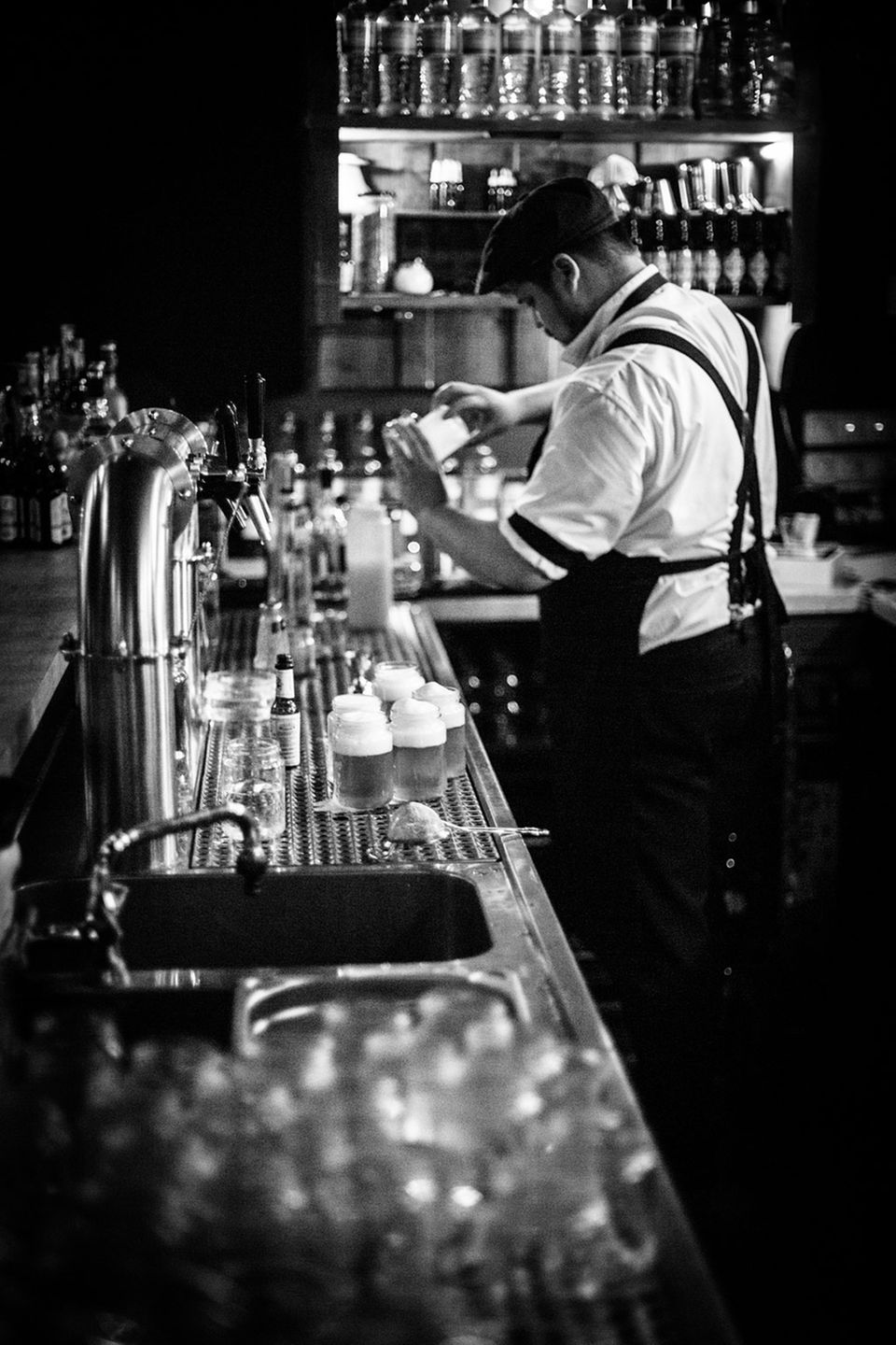 Bartender hinter der Bar "Kleines Phi" bei der Zubereitung leckerer Drinks Bartender hinter der Bar "Kleines Phi" bei der Zubereitung leckerer Drinks