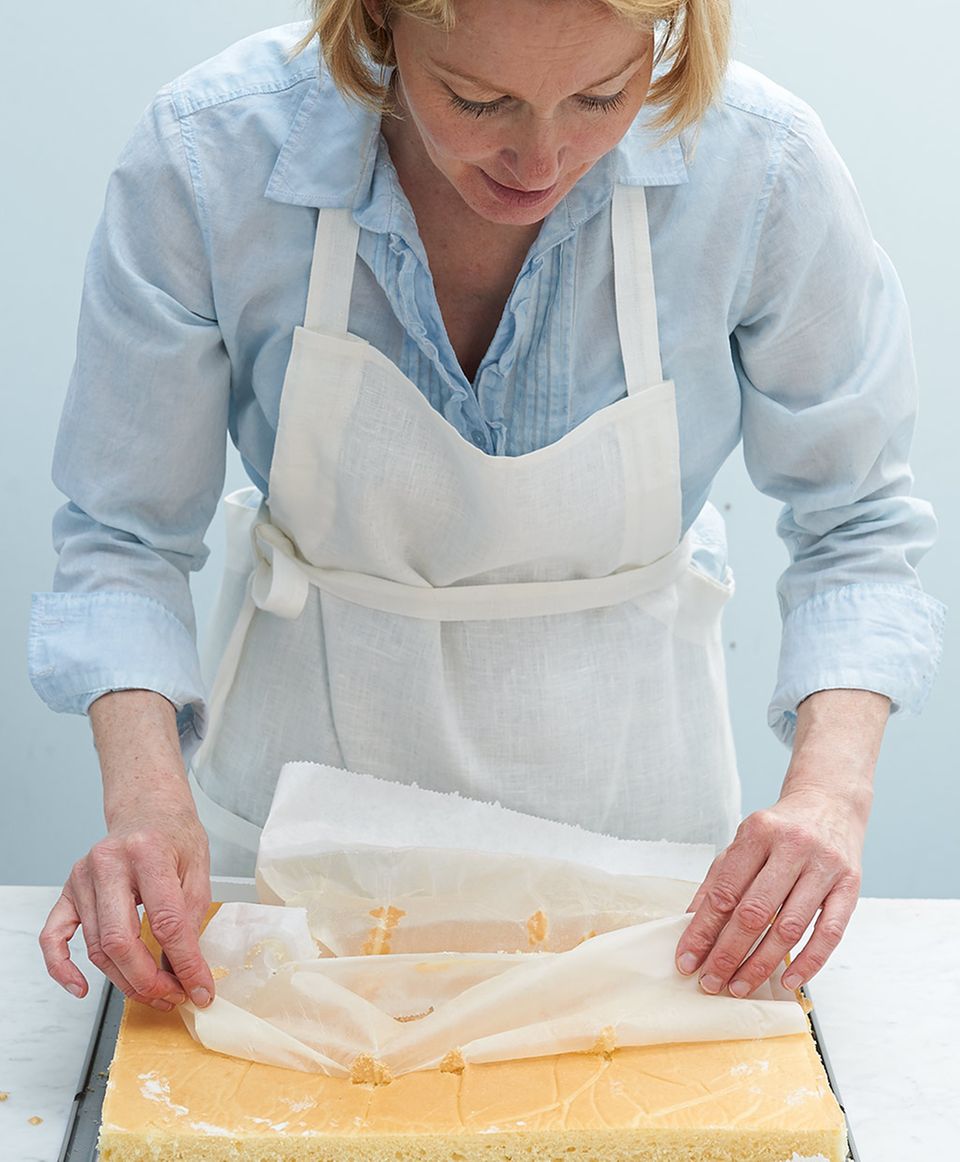 Anne Haupt zieht Backpapier von gestürztem Kuchenboden auf Backblech Anne Haupt zieht Backpapier von gestürztem Kuchenboden auf Backblech
