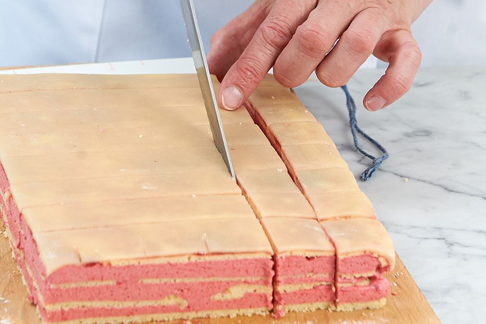 Kuchen mit einem scharfen Messer in Würfel schneiden