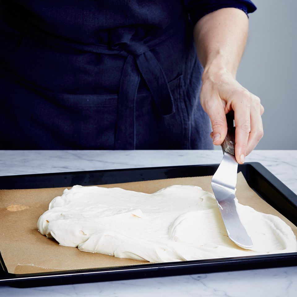 Biskuitteig mit einer Winkelpalette auf dem Backblech verteilen Biskuitteig mit einer Winkelpalette auf dem Backblech verteilen
