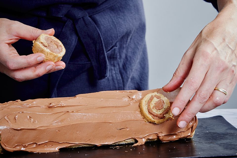 Biskuitrolle mit Schokoladenbuttercreme bestreichen und "Astlöcher" anbringen Biskuitrolle mit Schokoladenbuttercreme bestreichen und "Astlöcher" anbringen