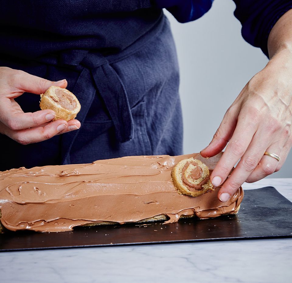 Biskuitrolle mit Schokoladenbuttercreme bestreichen und "Astlöcher" anbringen Biskuitrolle mit Schokoladenbuttercreme bestreichen und "Astlöcher" anbringen