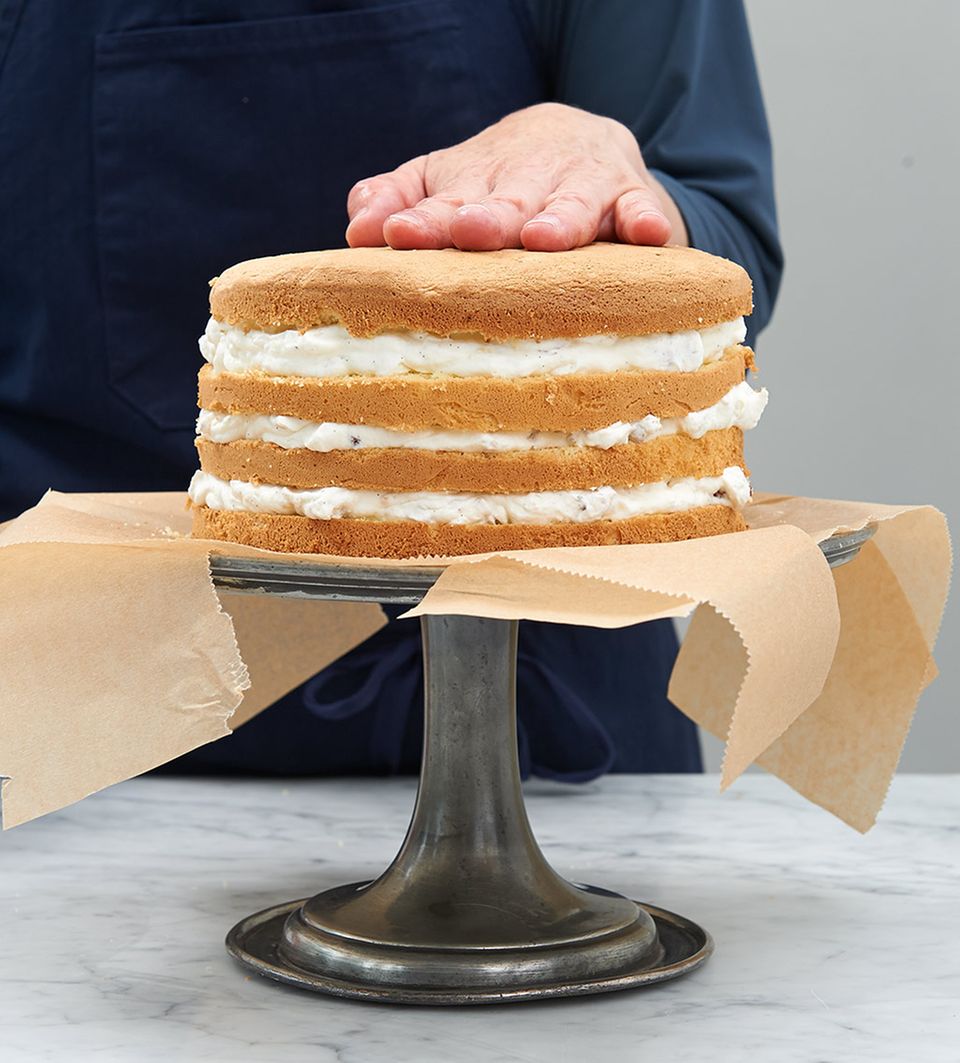 Biskuitböden und Nussahne zu Torte schichten Biskuitböden und Nussahne zu Torte schichten
