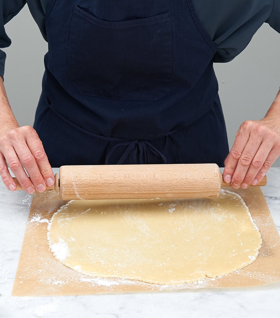 Marzipan mit dem Rollholz auf Backpapier ausrollen Marzipan mit dem Rollholz auf Backpapier ausrollen