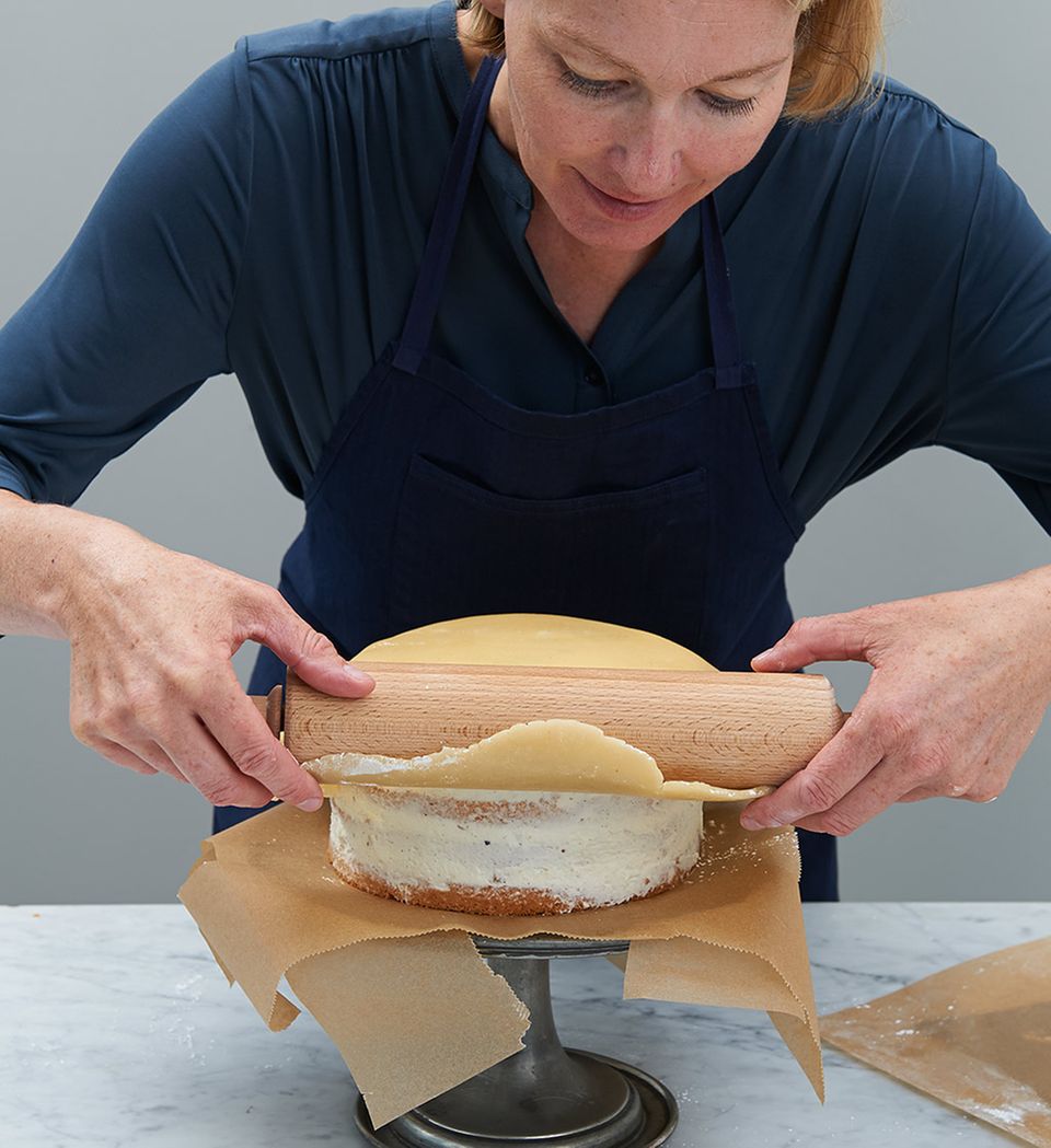 Marzipan mithilfe von Rollholz auf Torte legen Marzipan mithilfe von Rollholz auf Torte legen