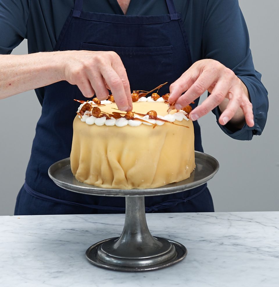 Die Torte mit feinen Karamellnüssen verzieren Die Torte mit feinen Karamellnüssen verzieren