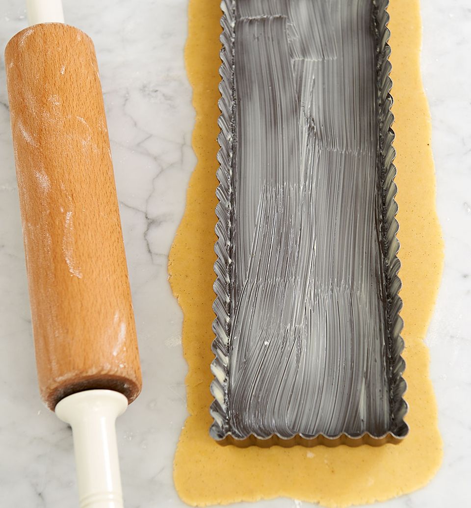 Die Tarteform ist hilfreich, um den Teig auf die richtige Größe auszurollen Die Tarteform ist hilfreich, um den Teig auf die richtige Größe auszurollen
