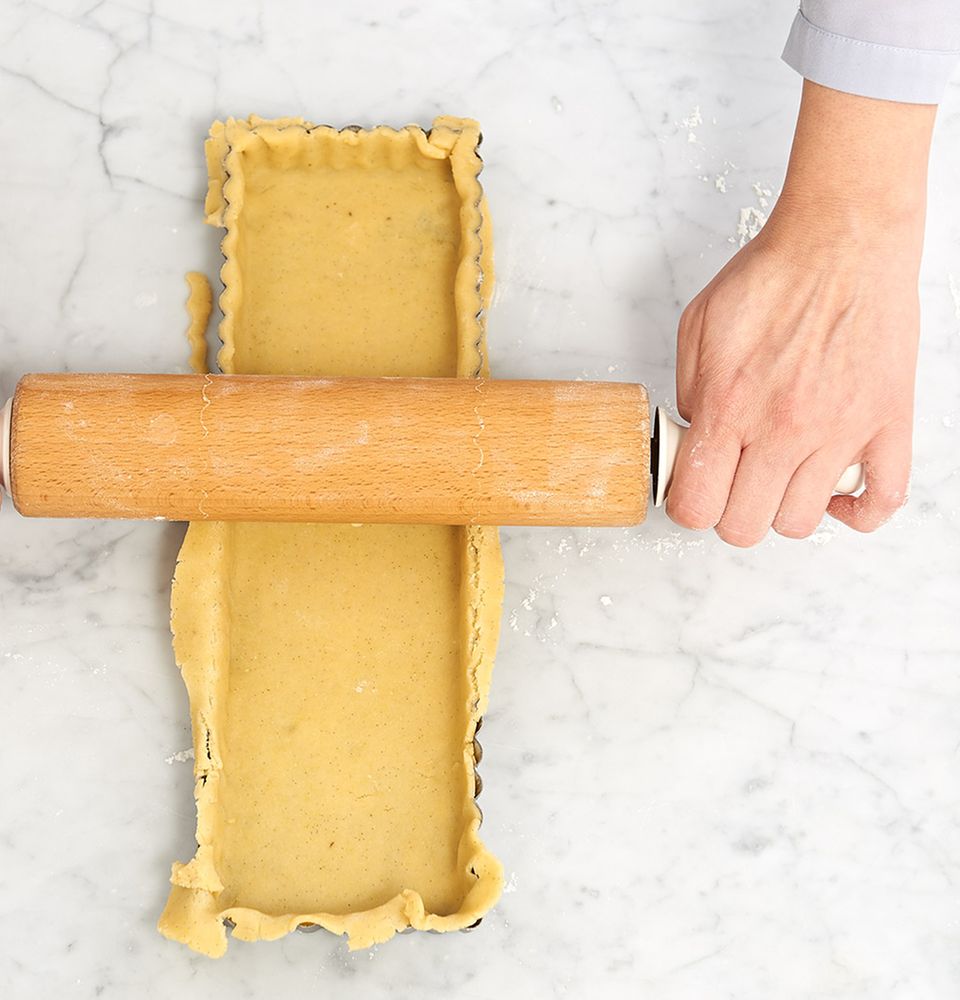 Teig in der Tarteform mit dem Rollholz begradigen Teig in der Tarteform mit dem Rollholz begradigen