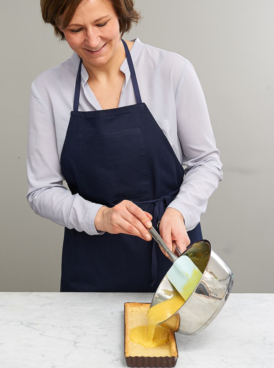 Marion Heidegger gießt die Eimischung gleichmäßig in die Tarteform Marion Heidegger gießt die Eimischung gleichmäßig in die Tarteform