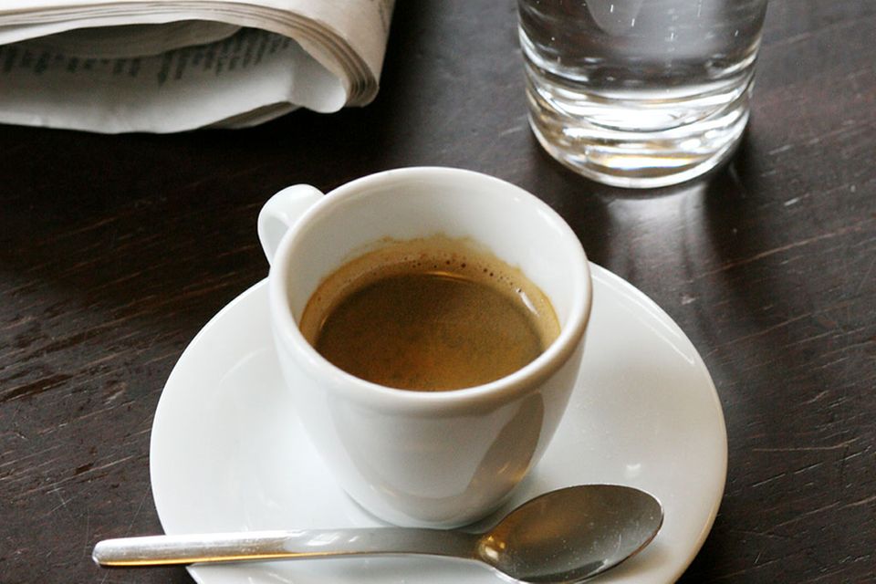 Espresso in Tasse mit einem Glas Wasser