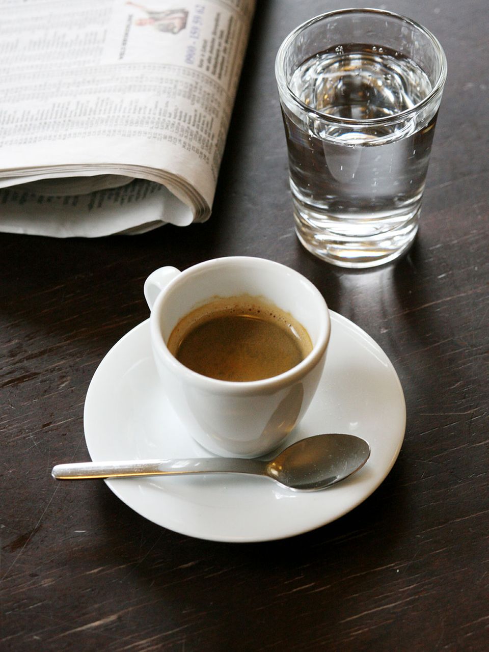 Espresso in Tasse mit einem Glas Wasser Espresso in Tasse mit einem Glas Wasser
