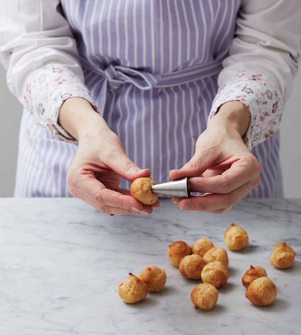 Das Anstechen der Profiteroles erleichtert das Füllen Das Anstechen der Profiteroles erleichtert das Füllen