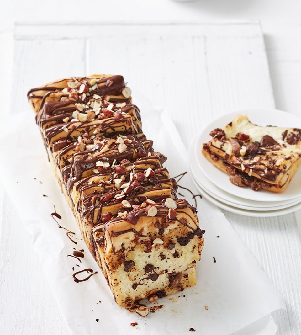 Beim Zupfbrot schichtet man Teigscheiben und Belag hochkant nebeneinander, hier in unserer Nougat-Version Beim Zupfbrot schichtet man Teigscheiben und Belag hochkant nebeneinander, hier in unserer Nougat-Version