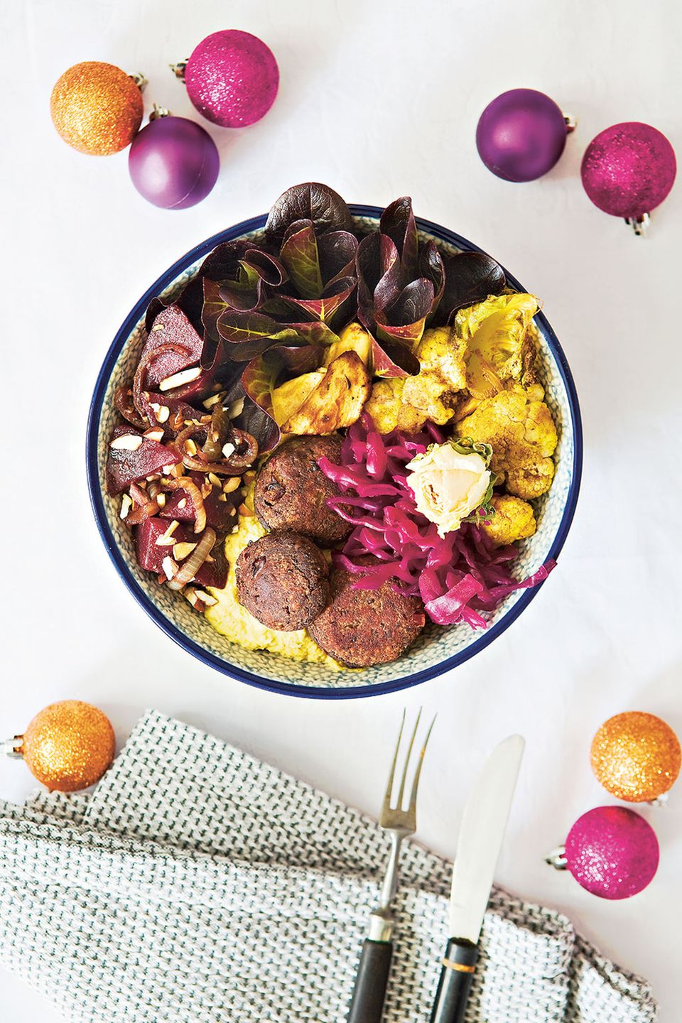 Die Christmasbowl ist eine bunte Mischung aus Zutaten wie Blumenkohl, Hummus, Rote-Bete-Salat und Bohnen-Talern Die Christmasbowl ist eine bunte Mischung aus Zutaten wie Blumenkohl, Hummus, Rote-Bete-Salat und Bohnen-Talern