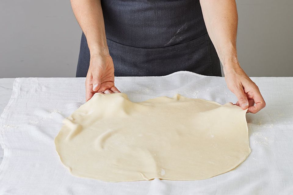 Strudelteig auf einem Tuch ausbreiten Strudelteig auf einem Tuch ausbreiten