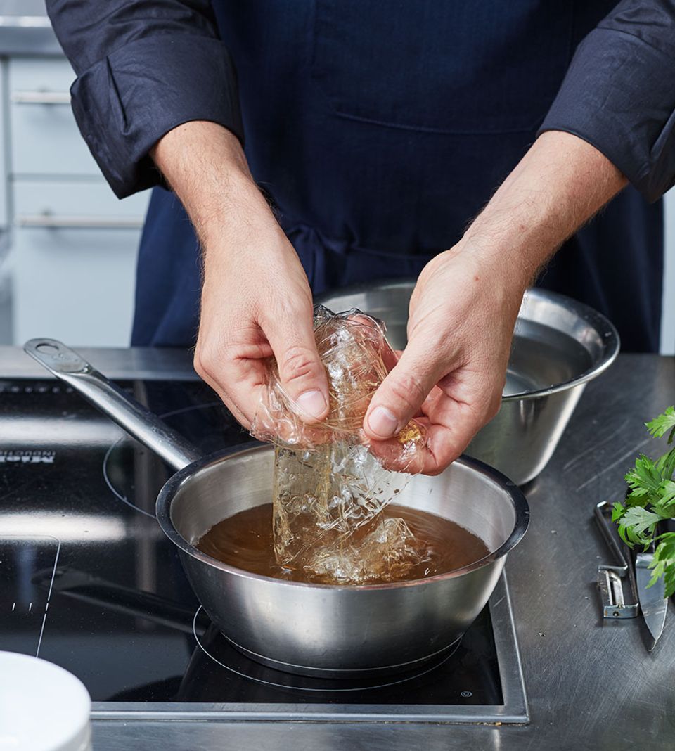 Die Gelatine unter Rühren in der warmen Brühe auflösen Die Gelatine unter Rühren in der warmen Brühe auflösen