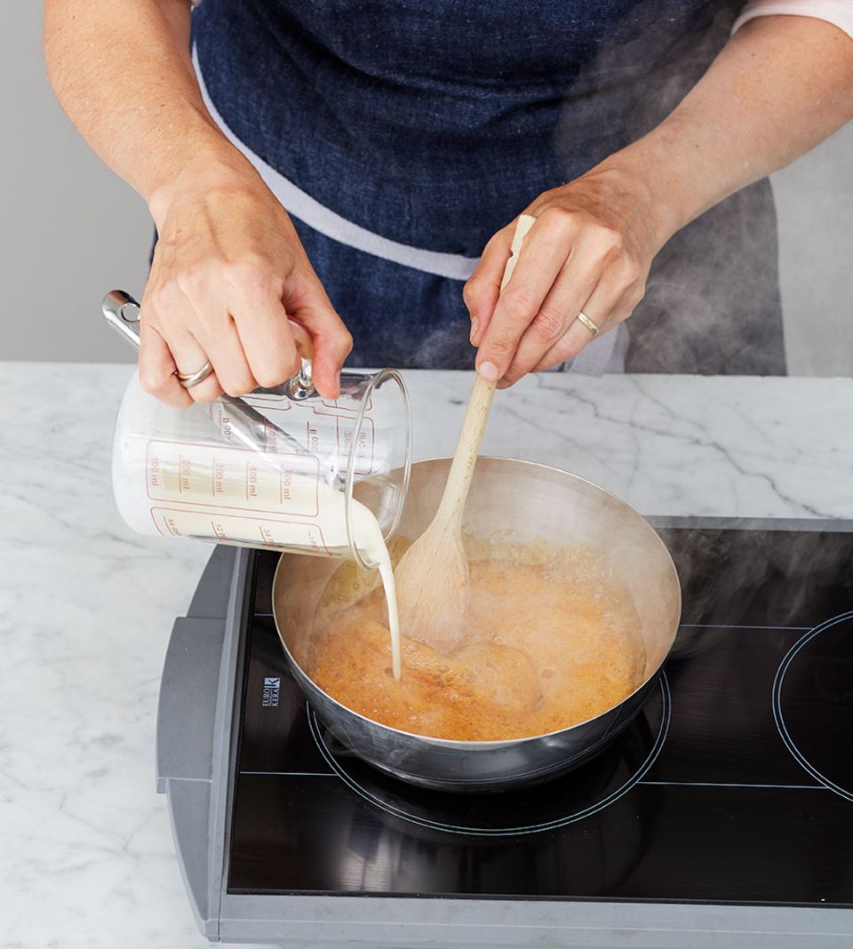 Sahne in die Zuckermasse einrühren und kurz aufkochen lassen Sahne in die Zuckermasse einrühren und kurz aufkochen lassen