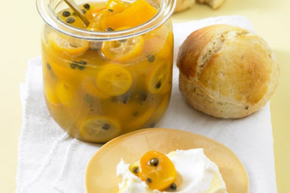 Scones und Kumquatkompott angerichtet auf einer weißen Servierte. Scones und Kumquatkompott angerichtet auf einer weißen Servierte.
