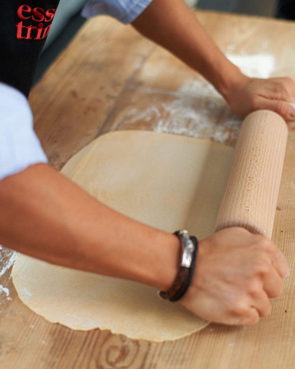 Nudelteig mit einem Rollholz ausrollen Nudelteig mit einem Rollholz ausrollen
