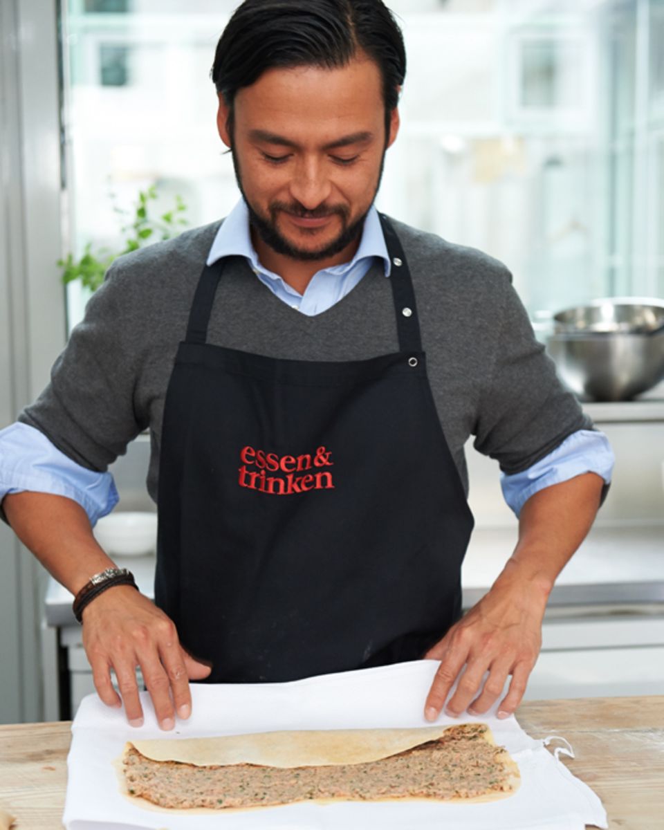 Marcel Stut rollt mithilfe eines Küchentuchs die Maultaschenrolle auf Marcel Stut rollt mithilfe eines Küchentuchs die Maultaschenrolle auf