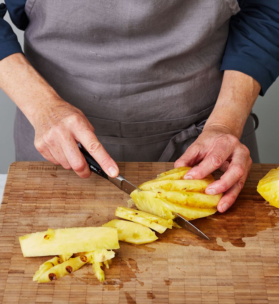Ananas-Viertel in dünne gleichmäßige Spalten schneiden, damit sie einheitlich backen. Ananas-Viertel in dünne gleichmäßige Spalten schneiden, damit sie einheitlich backen.