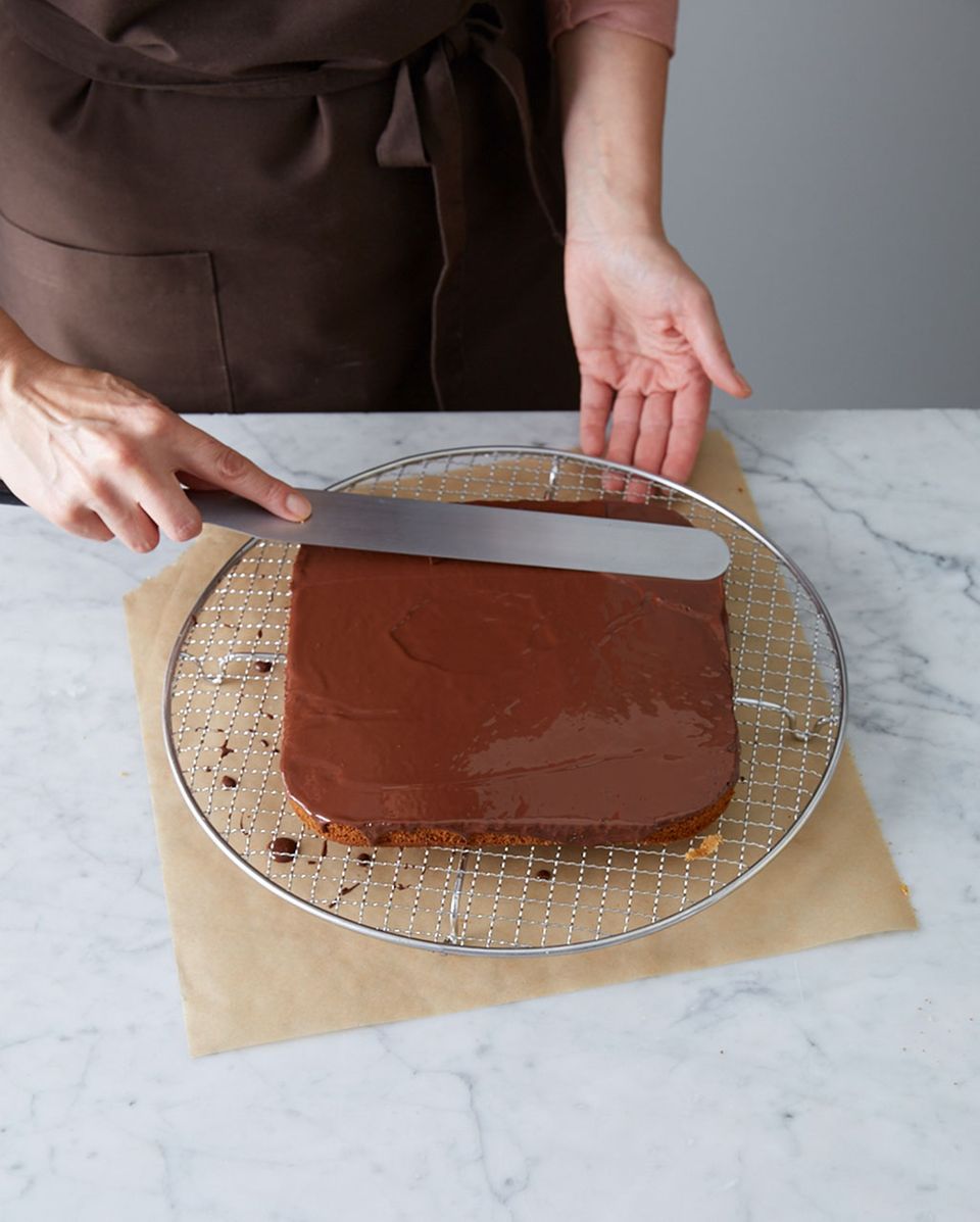 Dunkle Kuvertüre auf dem Honigkuchen glatt streichen. Dunkle Kuvertüre auf dem Honigkuchen glatt streichen.
