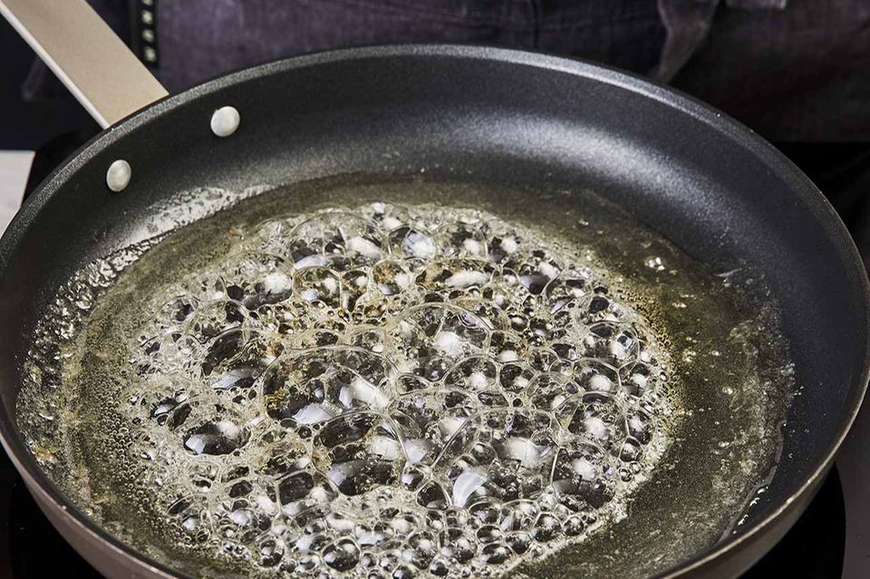 Zucker-Limettensaft-Mischung wird in der Pfanne gekocht, bis der Zucker geschmolzen ist. Zucker-Limettensaft-Mischung wird in der Pfanne gekocht, bis der Zucker geschmolzen ist.