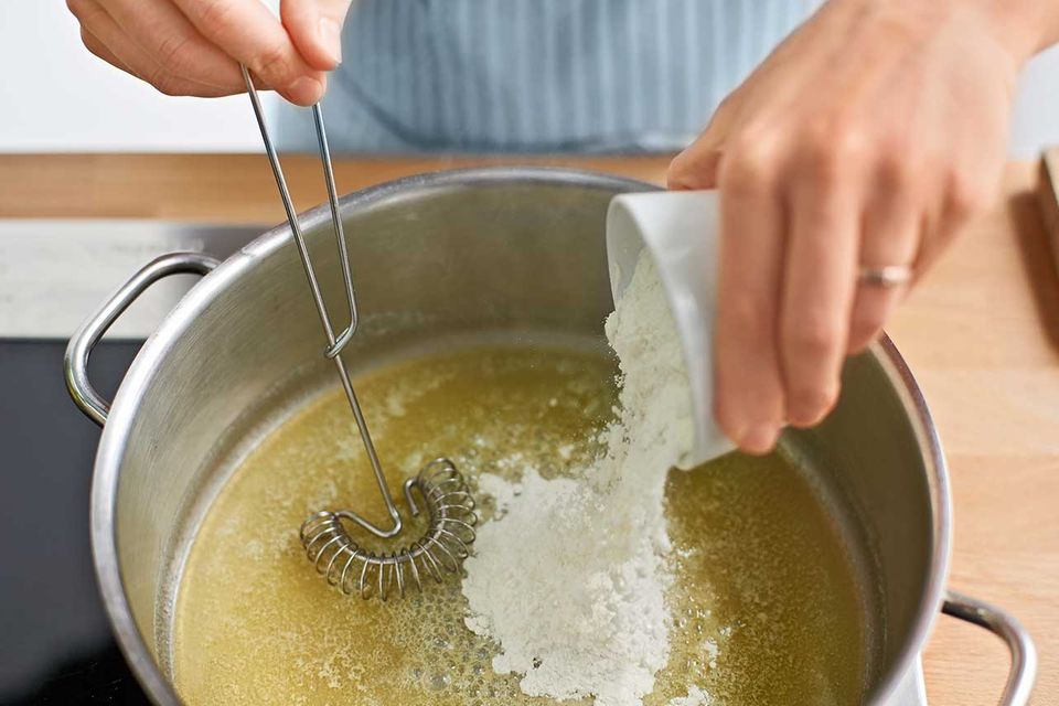 Mehl zur geschmolzenen Butter in den Topf geben