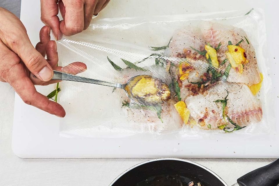 Vakuumbeutel mit Fisch und Kräutern befüllen