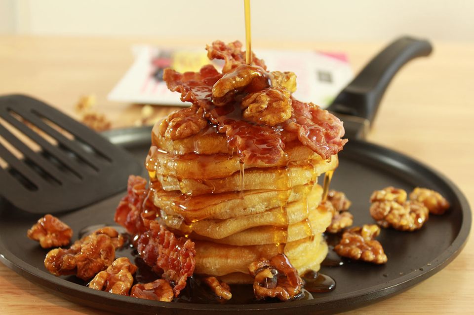 Frisch gebackene Pancakes mit Sirup, Nüssen und Bacon Frisch gebackene Pancakes mit Sirup, Nüssen und Bacon