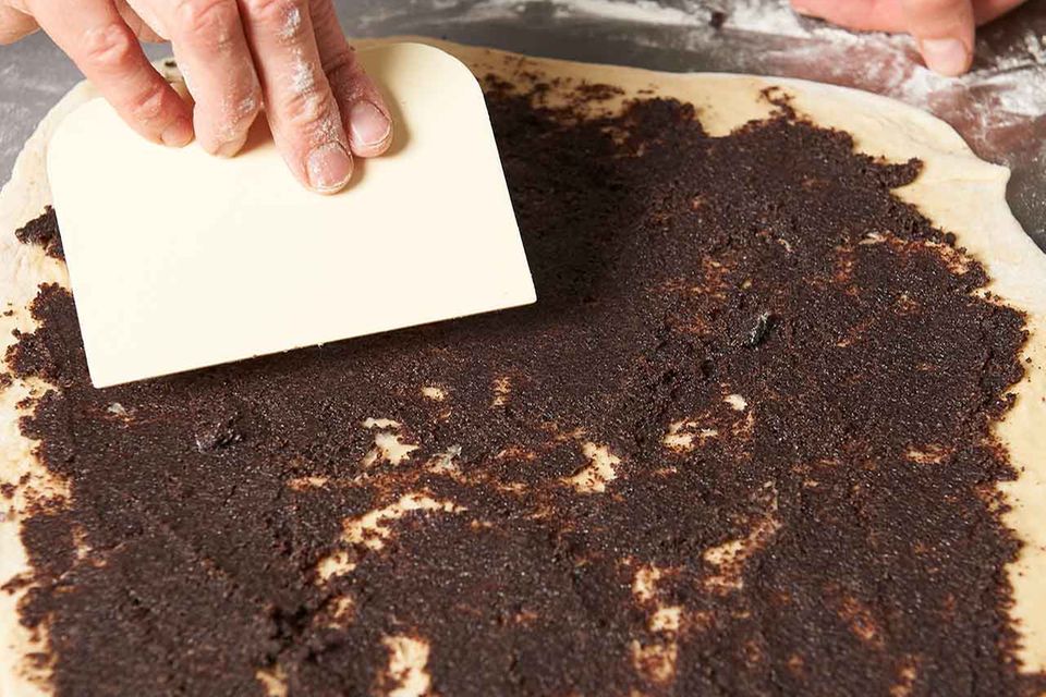 Zubereitung gefüllte Hefeschnecken: Teig mit Mohnmasse bestreichen