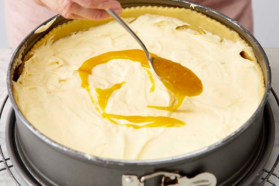 Maracuja-Topping auf Käsekuchen verteilen